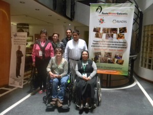 Participants in the DRPI Colombia training on disability rights pose in front of a banner for the training.