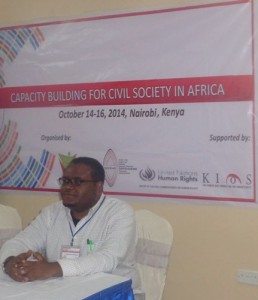 Dagnachew Wakene sits in front of a banner that says "Capacity Building for Civil Society in Africa"